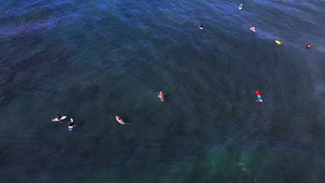 Surfistas-Flotando-En-El-Océano-Mientras-Las-Olas-Rompen-A-Su-Alrededor-En-Rincon-Puerto-Rico-Durante-Un-Día-Despejado-Con-Cielo-Azul