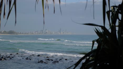 Crashing-Sea-Waves---Burleigh-Heads-Beach-With-Distant-City-Landscape-In-Gold-Coast,-Queensland,-Australia