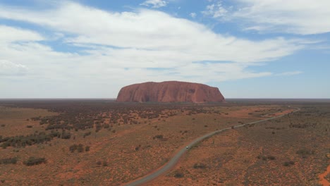 Traveling-Car-In-Road-Near-Ayers-Rock-At-Uluru-Kata-Tjuta-National-Park-In-Northern-Territory,-Australia