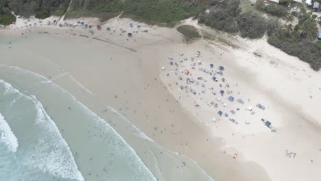 Tourist-On-Campground-With-Splashing-Sea-Waves---Cylinder-Beach,-North-Stradbroke-Island-In-Queensland-Australia