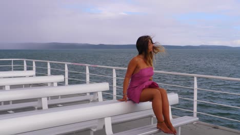 Sexy-Young-Woman-In-Pink-Dress-Sitting-On-Chair-At-Ferry-Deck---Ferry-Boat-Heading-To-Island-Of-North-Stradbroke-In-QLD,-Australia