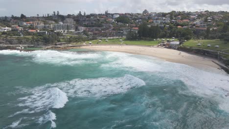 Foamy-Ocean-Waves-Rolling-In-Bronte-Beach-With-Seaside-Park---Sydney,-NSW,-Australia
