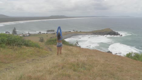 Sexy-Caucasian-Woman-Standing-And-Raising-Hands-In-The-Air-On-A-Windy-Morning---Crescent-Head-Lookout-At-Crescent-Head-Of-Sydney-In-Kempsey-Shire,-New-South-Wales,-Australia