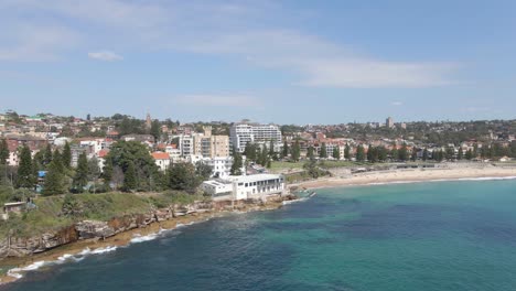 Coogee-Surf-Life-Saving-Club-Am-Coogee-Beach-Mit-östlichen-Vororten-Im-Hintergrund-In-Sydney,-New-South-Wales,-Australien