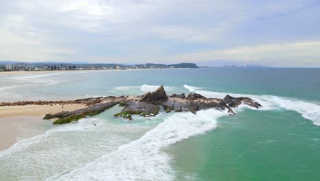 Currumbin-Rock-At-Currumbin-Beach-With-Rolling-Waves-From-Coral-Sea---Gold-Coast,-Queensland,-Australia