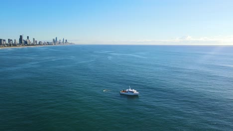 Boat-Adrift-In-Blue-Ocean-Against-Sunlight