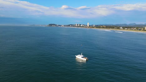 Barco-Blanco-Flotando-En-El-Agua-Azul-Del-Océano-En-Verano---Miami-Beach-En-Gold-Coast,-Qld,-Australia