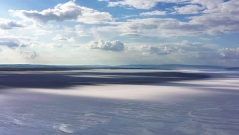 Aerial-view-of-salt-lake-with-beautiful,-cloudy,-blue-sky