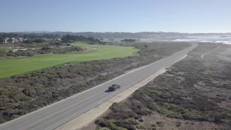 Vehicle-aerial-view-following-along-California-state-route-1-driving-road-trip-travel-vacation