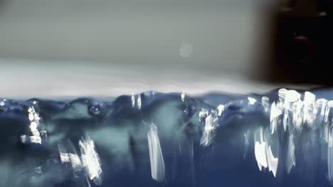 Nahaufnahme-Von-Luftblasen,-Die-Sich-über-Und-Unter-Wasser-Bilden