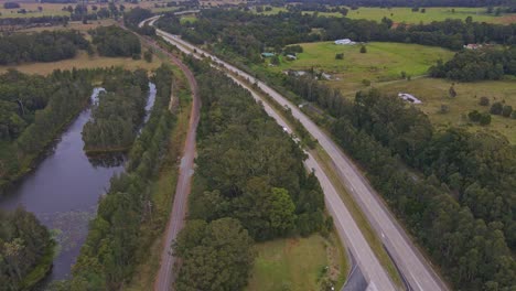 Aerial-View-Of-Cars-Driving-At-Pacific-Highway-Passing-By-Johns-River-Locality-Near-Middle-Brother-National-Park,-NSW,-Australia