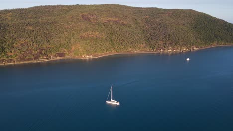 Sailboat-Adrift-On-The-Surface-Of-Hook-Island-In-Whitsunday-Area-With-Lush-Green-Inlet-In-Background