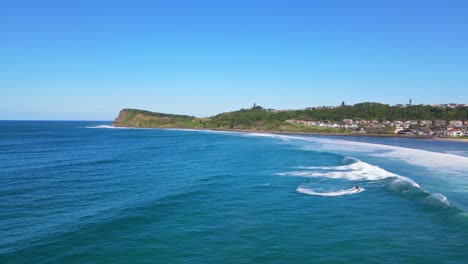 Blue-Sea-With-Panorama-Of-Lennox-Headland-And-Beach---Jetskiing-On-The-Beach-In-NSW,-Australia