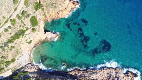 Luftaufnahme-Des-Strandes-Von-Cala-Tio-Ximo-Mit-Kristallklarem-Blauem-Wasser-Tagsüber-In-Alicante,-Spanien