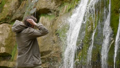 Hiking-on-an-overcast-day---A-young-male-hiker-stops-to-admire-the-waterfalls-and-removes-his-hood---The-Route-of-the-Seven-Pools---Catalonia-Spain---Ruta-dels-Set-Gorgs-de-Campdevànol