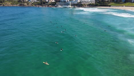 Surfing-At-Bondi-Beach,-NSW,-Australia---Surfers-Lying-On-Surfboard-Waiting-For-Perfect-Waves-To-Surf