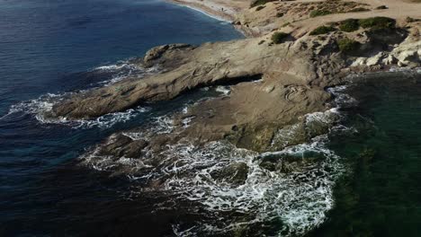 Aerial-shot-of-waves-hitting-the-rocky-bay