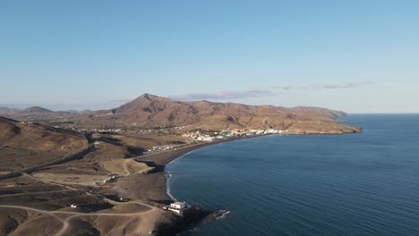 Video-Aéreo-De-Drones-De-Un-Pequeño-Pueblo-En-El-Lado-Costero-De-La-Isla-Fuerteventura-Mientras-Se-Pone-El-Sol