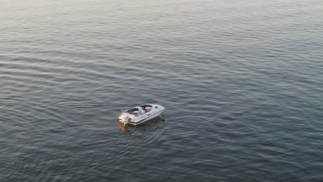 Isoliertes-Motorboot-Mitten-Im-Blauen-Ozean-Bei-Sonnenuntergang