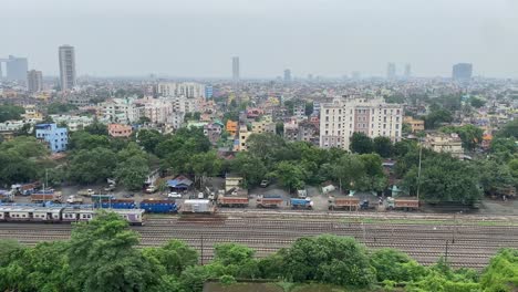 Aerial-view-of-a-moving-train-and-multiple-tracks-with-a-beautiful-city-view