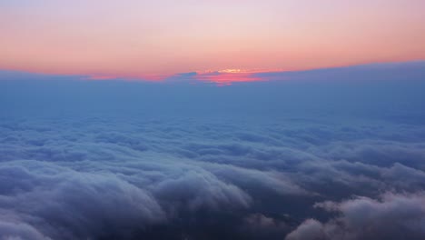 Camera-is-raising-above-from-the-thick-fog-above-the-beautiful-ocean-of-clouds-at-sunrise