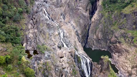 Aerial---drone-shot-of-multiple-waterfalls-cascading-down-rocky-mountainside,-Queensland