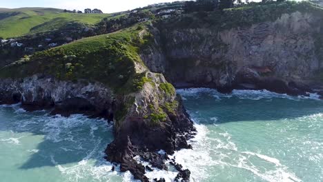 Aerial---Beautiful-New-Zealand-coastline,-village-on-rocky-cliffs-and-turquoise-beaches