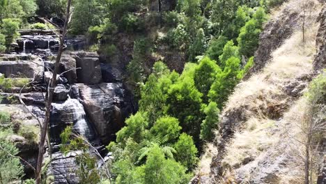 Aerial---Waterfall-cascades-over-rock-face-in-Australian-outback