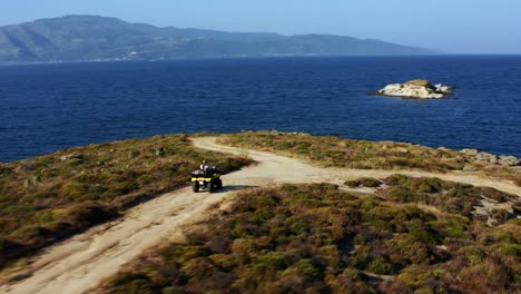 Drone-shot-of-woman-driving-ATV-by-the-sea