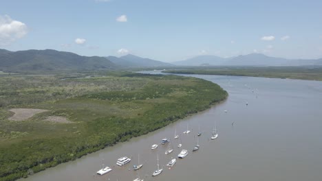 Row-Of-Boats-Anchored-At-Chinaman-Creek-With-Trinity-Forest-Reserve---Nature-Reserve-Near-Cairns,-Australia