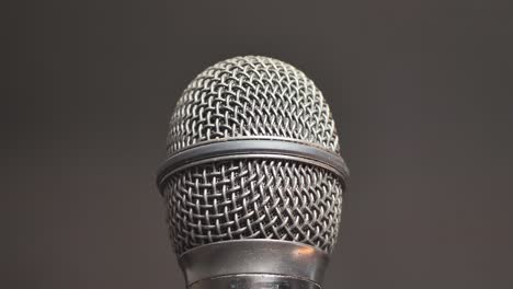 Extreme-closeup-of-old-dirty-stereo-microphone-head,-spinning