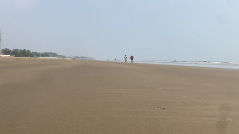 Zeitraffervideo-Eines-Wunderschönen-Strandes,-An-Dem-Menschen-Vor-Einem-Natürlichen-Hintergrund-Sprechen-Und-Auf-Dem-Sand-Spazieren-Gehen