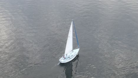 Sailing-Ship-In-The-Middle-Of-Ocean-With-Reflections-On-Water---aerial-drone-shot