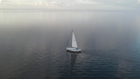 Sailboat-Sailing-On-A-Cloudy-Day---aerial-drone-shot