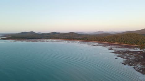 Pristine-Blue-Beach-And-Hilly-Landscape-At-Sunset-In-Clairview-Beach-At-The-Australian-State-Of-Queensland