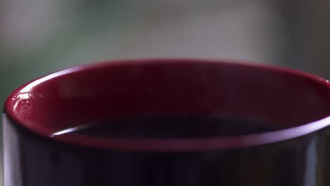 Close-up-of-coffee-dripping-into-a-steaming-mug,-4K