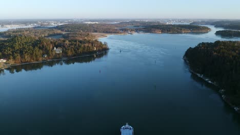 Aerial-view-of-general-cargo-vessel-making-way-ahead-during-winter-morning-in-Finnish-archipelago-while-approaching-port-of-Turku