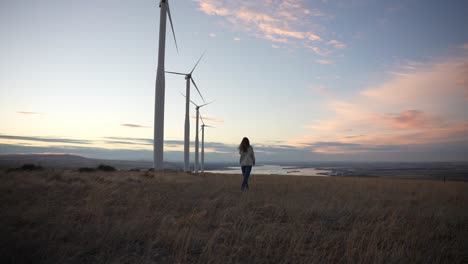 Model-walking-below-windmills-at-sunset-in-slow-motion