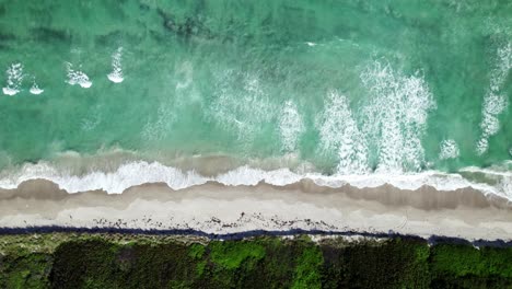 Straight-down-drone-shot-of-waves-crashing-over-the-shore-on-Hutchinson-Island-in-south-Florida