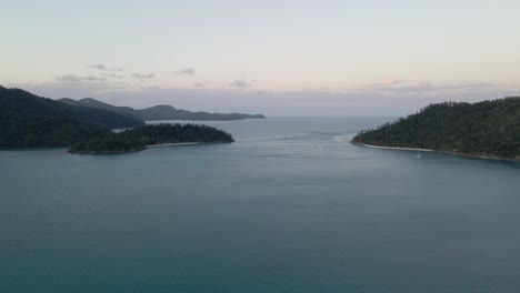 Distant-View-Of-A-Sailboat-On-Calm-Waters-Of-Hook-Passage-In-Whitsundays,-QLD,-Australia-At-Sunset