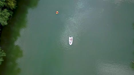 Eine-Pull-up-Aufnahme-Eines-Weißen-Bootes,-Das-Auf-Einem-Breiten-Fluss-Sitzt