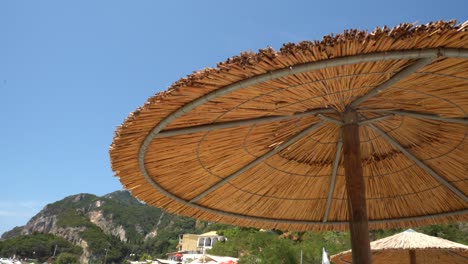 Am-Strand,-Sitzen-Im-Schatten-Unter-Dem-Sonnenschirm-In-Griechenland