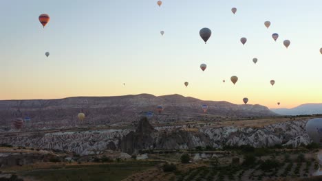 Luftdrohnenansicht-Des-Bunten-Heißluftballons,-Der-Bei-Sommerlichem-Sonnenaufgang-über-Kappadokien-Fliegt