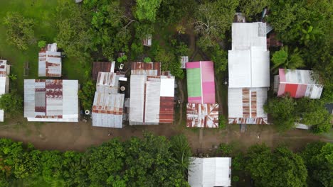 Birds-eye-view-ascending-shot,-scenic-view-of-the-roofs-of-Puerto-Narino-in-the-middle-of-the-amazon-forest-in-Colombia
