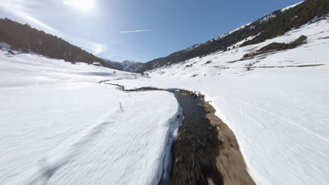 Creek-flowing-in-snowy-Incles-valley,-Andorra