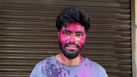 4K-Portrait-of-serious-hipster-guy-standing-still-while-being-covered-in-colored-powder-at-festival