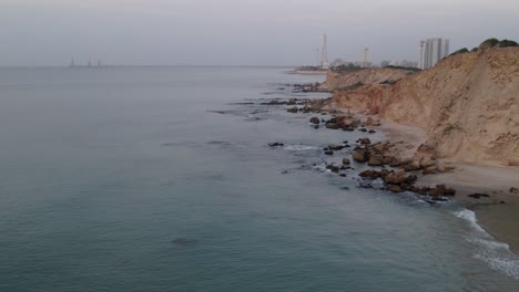 Israel,-Mediterranean-rocky-coastal-shot-at-Dor-Beach-panning-left-to-right-at-sunset