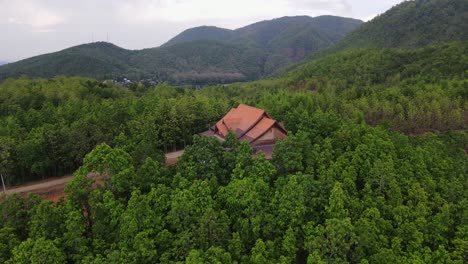 Aerial-shot-of-alone-house-situated-in-between-the-dense-forest-at-Ban-Mae-Saring,-Chiang-Mai,-Thailand