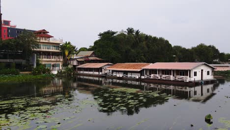 Ein-Erstaunlicher-Blick-Auf-Viele-Holzhäuser,-Die-Auf-Dem-Fluss-Mit-Bergen-In-Kanchanaburi,-Thailand,-Schwimmen