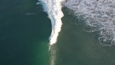 Surfer-Riding-The-Waves-At-Fingal-Bay-Beach-During-Summer-In-NSW,-Australia---aerial-drone-shot